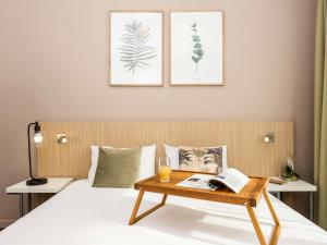 a bedroom with a bed with a table on it at Aparthotel Adagio Access Paris Maisons-Alfort in Maisons-Alfort