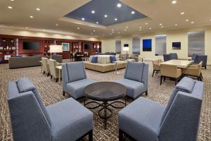 une salle d'attente avec des chaises et des tables dans un bâtiment dans l'établissement Hyatt Regency Tulsa Downtown, à Tulsa