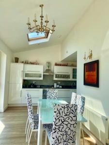 a kitchen with a table and chairs and a chandelier at Large One Bedroom House near Twickenham stadium in Isleworth