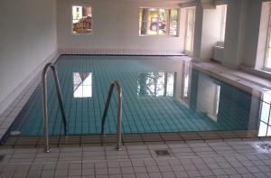 an empty swimming pool with green tiles on the floor at Ferienclub Erlenbruck in Hinterzarten