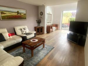 a living room with a couch and a coffee table at Large One Bedroom House near Twickenham stadium in Isleworth