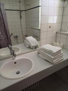 a bathroom with a sink and a mirror and towels at Ferienclub Erlenbruck in Hinterzarten +11 photos