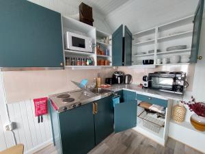 a small kitchen with blue cabinets and a sink at The perfect stop in Lødingen