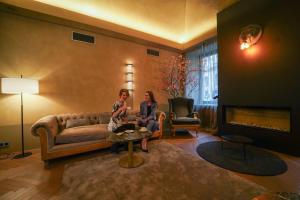 two women sitting on a couch in a living room at 987 Design Prague Hotel in Prague