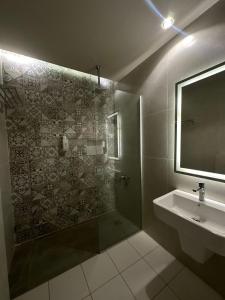 a bathroom with a shower and a sink and a mirror at Pasha Boutique Hotel in Amman