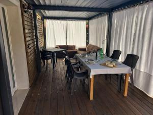 a room with a table and chairs on a deck at Bergamo - La Casa Di Gianna in Nembro