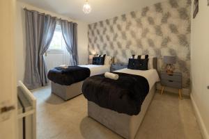 1 dormitorio con 2 camas y ventana en Royal Retreat & Lego Lodge with free parking! en Windsor