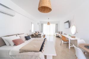 una camera bianca con un grande letto e un soggiorno di Alpha Urban Suites a Città di Rodi
