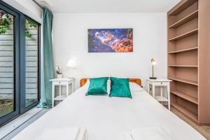 1 dormitorio con 1 cama blanca grande con almohadas verdes en Pass the Keys Modern Home-Private Parking-Garden en Londres