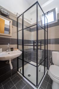 bagno con box doccia in vetro e servizi igienici di Alpha Urban Suites a Città di Rodi