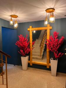 a staircase with red flowers in white vases at ORHO AIRPORT PANAMA in Tocumen