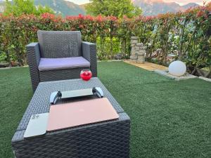 een tuin met een tafel, een stoel en een boek bij Lario House in Limonta