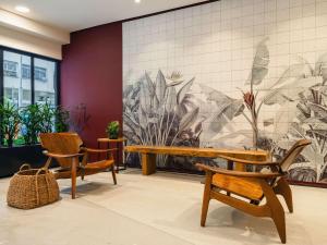 a lobby with two chairs and a bench and a mural at Grand Mercure Rio de Janeiro Copacabana in Rio de Janeiro