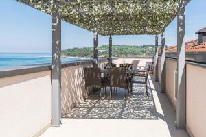 Hotel Lavender - Oleander Resort في سترونجان: فناء مع طاولة وكراسي والمحيط