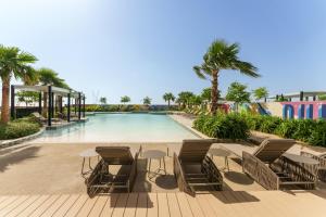 - une piscine dans un complexe avec des chaises et une table dans l'établissement Maison Privee - City Chic Retreat in Dubai Prime Location, à Dubaï