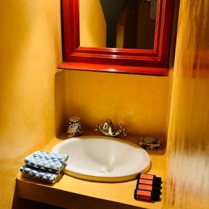 a bathroom with a sink and a red mirror at Mediterraneo Hotel in Meyisti