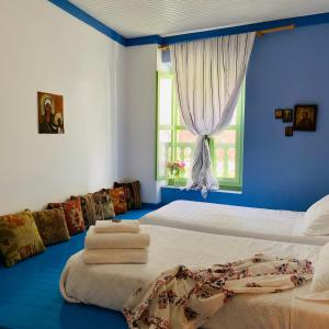Habitación azul con cama y toallas. en Mediterraneo Hotel, en Meyisti