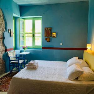 um quarto azul com uma cama e uma janela em Mediterraneo Hotel em Meyisti