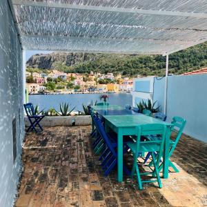 einen Tisch und Stühle auf einer Terrasse mit Blick auf das Wasser in der Unterkunft Mediterraneo Hotel in Megisti