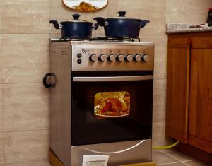 - une cuisinière avec 2 casseroles dans la cuisine dans l'établissement Appartement meublé type T2, à Godomè