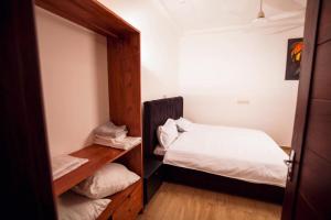 een kleine kamer met een bed en een spiegel bij Appartement meublé type T2 in Godomè