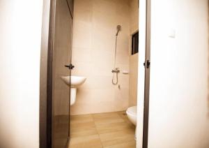 La salle de bains est pourvue d'une douche et de toilettes. dans l'établissement Appartement meublé type T2, à Godomè