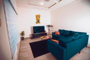 sala de estar con sofá azul y TV en Appartement meublé type T2 en Godomè