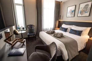 une chambre d'hôtel avec un lit et une chaise dans l'établissement Best Western Premier Le Chapitre Hotel and Spa, à Remiremont
