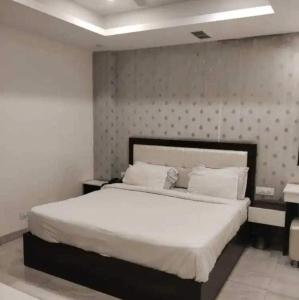 a bedroom with a large white bed in a room at OYO Hotel silver stone in Najafgarh