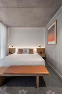 Vibe Hotel Adelaide في أديلايد: غرفة نوم بسرير كبير وطاولة
