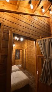 a room with two beds in a wooden cabin at KRZ Cottages أكواخ الكرز in Al Shafa