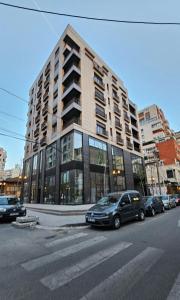 a large building with cars parked in front of it at Center Apartment Easy_Luxury in Tirana +58 photos