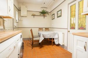 uma cozinha com mesa e cadeiras num quarto em Lovely cosy 2 bed cottage on the Wirral Peninsula em Birkenhead