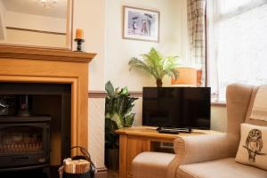 a living room with a television and a fireplace at Lovely cosy 2 bed cottage on the Wirral Peninsula in Birkenhead
