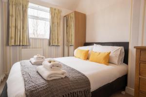 a bedroom with a bed with towels on it at Lovely cosy 2 bed cottage on the Wirral Peninsula in Birkenhead