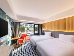 a hotel room with two beds and a window at Mondrian Seoul Itaewon in Seoul