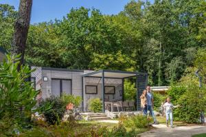 a family standing in front of a tiny house at Nantes Camping Le Petit Port in Nantes