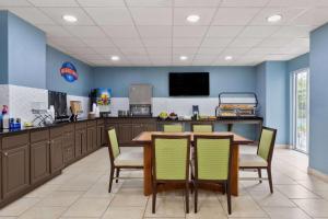 uma cozinha com mesa e cadeiras e uma televisão em Baymont by Wyndham Orlando-International Dr-Universal Blvd em Orlando