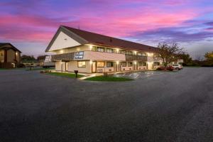 a large building with a parking lot at dusk at Suburban Studios Peoria in Peoria