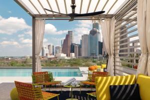 eine Terrasse mit Stühlen und Stadtblick in der Unterkunft Thompson Houston, by Hyatt in Houston