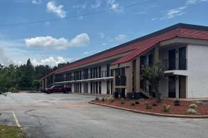 a building with a car parked in a parking lot at Ramada by Wyndham Bainbridge in Bainbridge