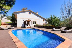 a swimming pool in front of a house at Boscos Villa - PlanetCostaDorada in Tarragona