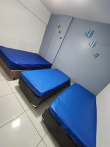 duas camas num quarto com lençóis azuis em 100 m da praia elevador garagem e portao automático em Mongaguá