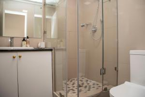 W łazience znajduje się prysznic ze szklanymi drzwiami. w obiekcie Waterfront, 17 Quay West w mieście Knysna