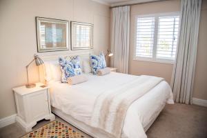 sypialnia z dużym białym łóżkiem z niebieskimi poduszkami w obiekcie Waterfront, 17 Quay West w mieście Knysna