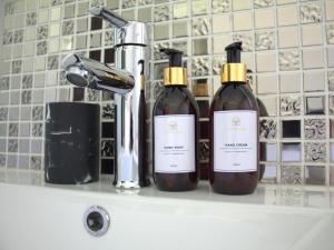伯诺尼Wild Tree Lodge的水槽顶部有三瓶葡萄酒