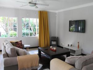 a living room with two couches and a coffee table at Wild Tree Lodge in Benoni