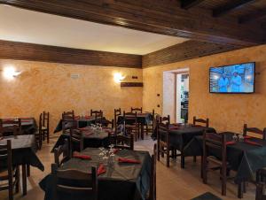 un restaurante con mesas y sillas y TV en la pared en Hotel il Rifugio del Lupo scanno, en Scanno