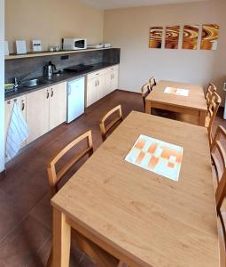 a kitchen with wooden tables and chairs and a kitchen with a counter at Hotel Toč in Lipova Lazne