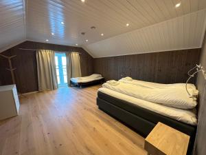 a bedroom with a large bed and a wooden floor at Lofoten Panorama in Stamsund